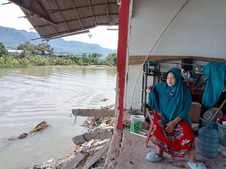 Salah seorang warga berada di bagian rumahnya yang tersisa, Senin (11/10). Sebelumnya, abrasi Sungai Batang Anai pada Rabu 29 September lalu menghanyutkan sebagian bangunan rumahnya. IRHAM