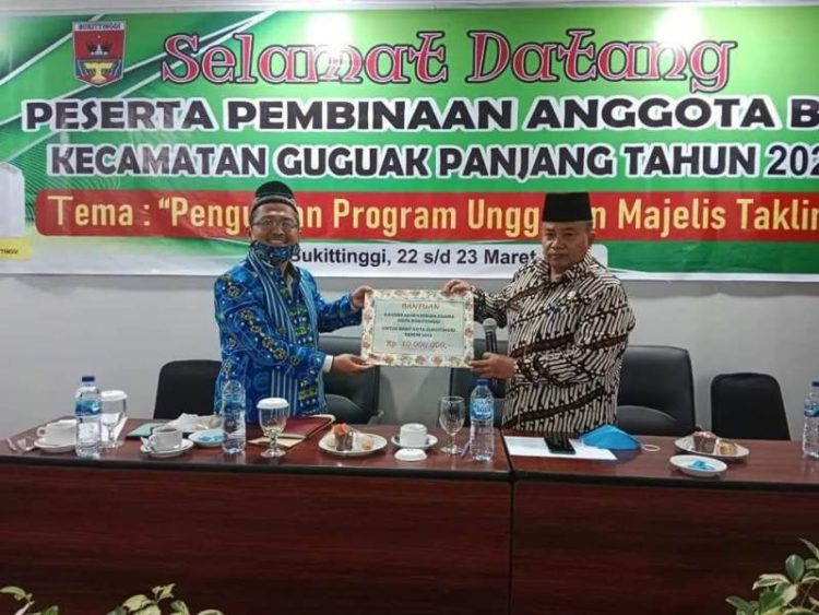 Kepala Kemenag Bukittinggi, Kasmir menyerahkan bantuan operasional kepada Ketua BKMT Bukittinggi, Syamsul Bahri, Rabu (23/3/2022). IST