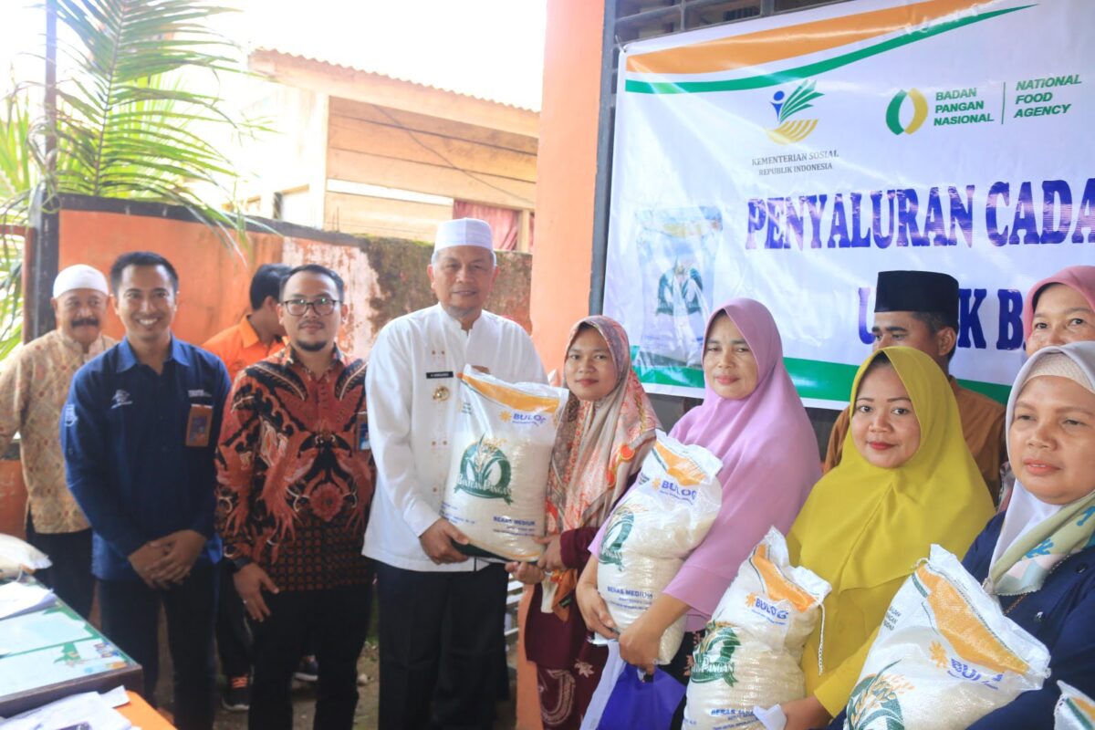 Bupati Risnawanto menyerahkan bantuan beras kepada penerima manfaat. Osniwati