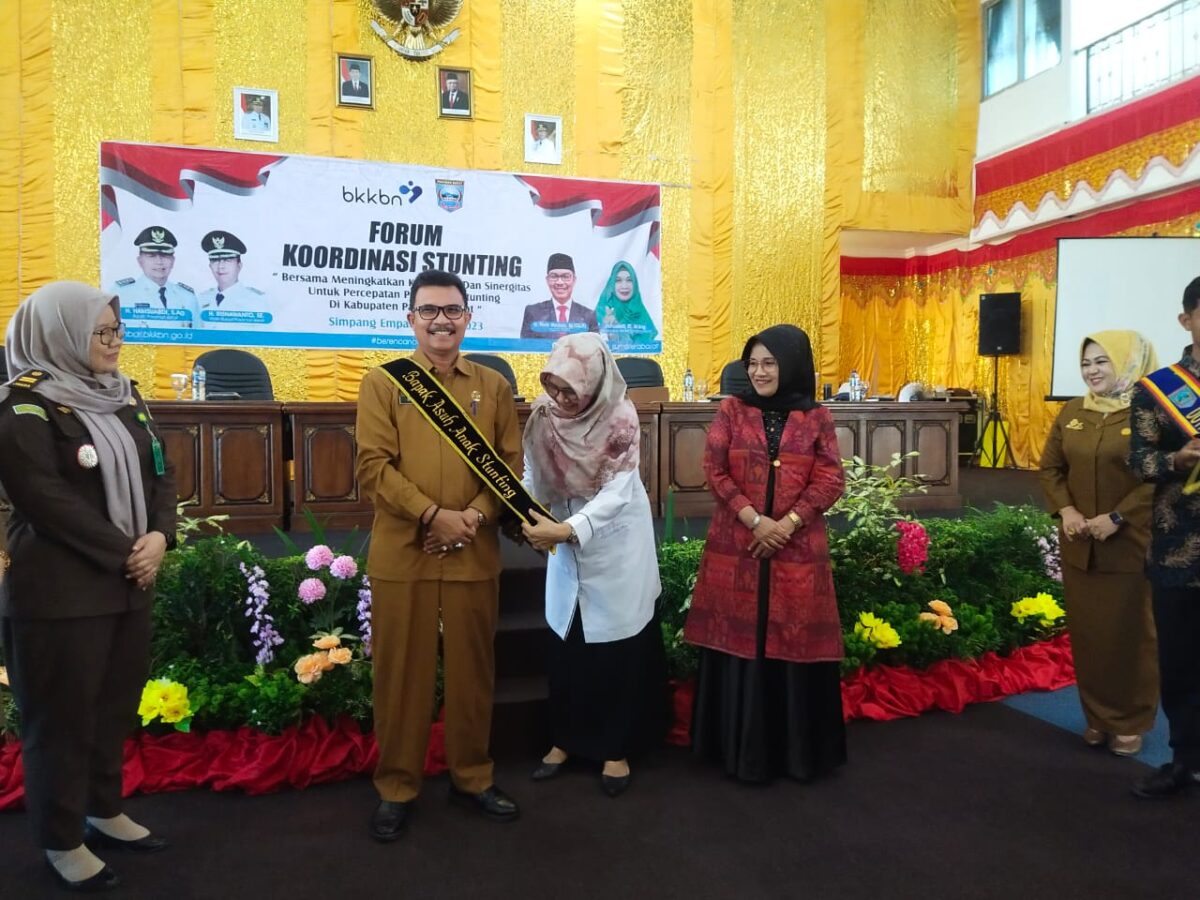 Sekretaris Perwakilan BKKBN Sumatera Barat Nova Dewita memasang tanda Bapak Asuh Anak Stunting kepada Asisten III Raf'an.  OSNIWATI