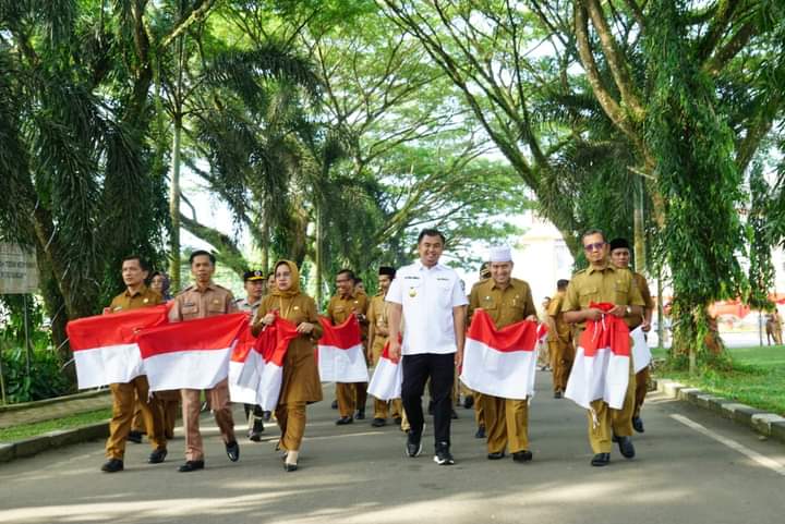 Bupati Dharmasraya Sutan Riska Tuanku Kerajaan saat melaksanakan Gerakan Pembagian Bendera Merah Putih Tahun 2023 secara simbolik, di halaman kantor bupati setempat, Senin (3/7). BADRI.