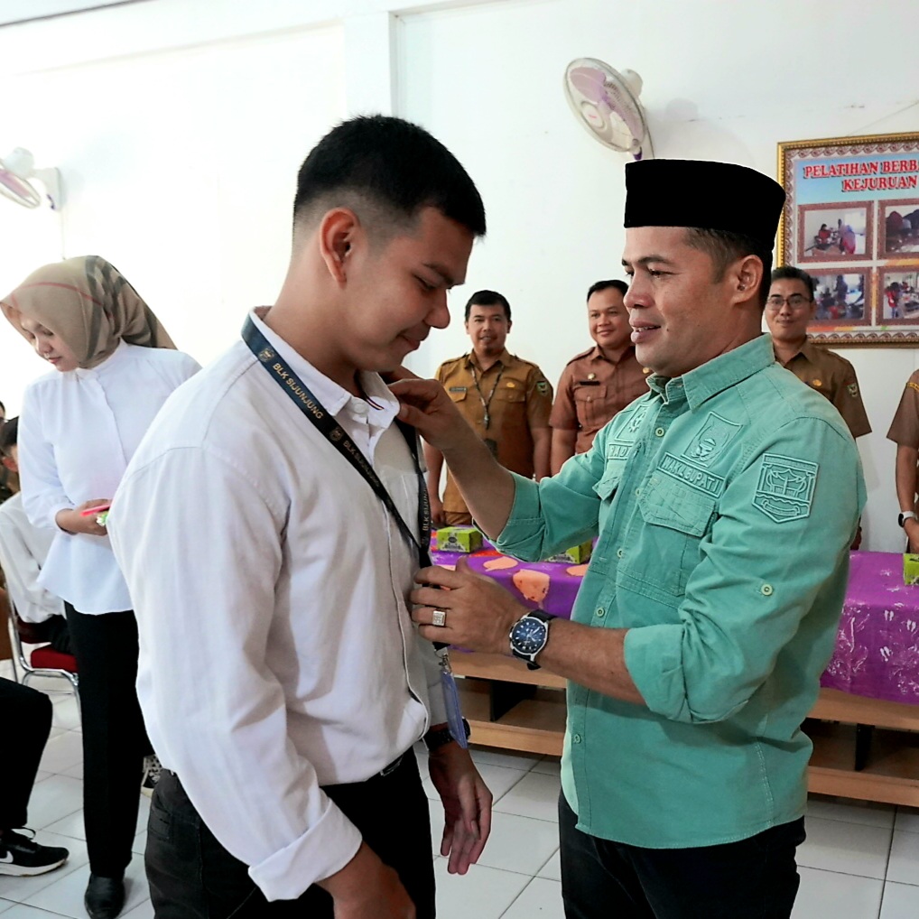 Wakil Bupati Sijunjung H.Iradatillah S.Pt memasangkan tanda pengenal kepada peserta pelatihan berbasis kompetensi kejuruan servis sepeda motor injeksi, Senin (11/9) di UPTD BLK Sijunjung. OGI