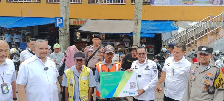 Wamenaker Afriansyah Noor, Bupati Tanah Datar Eka Putra dan Direktur BPJS Ketenagakerjaan Wilayah Sumbar Riau Eko Saat menyerahkan kartu BPJS secara simbolis di Pasar Batusangkar, Rabu (18/10). REZKY