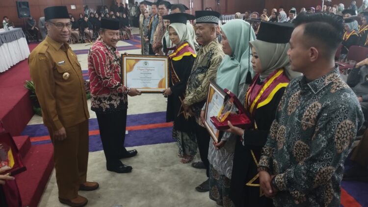 Bupati Agam Andri Warman beserta Wakil Wali Kota Bukittinggi Marfendi menyerahkan penghargaan untuk wisudawan/ti terbaik dalam Wisuda Ahli Madya Angkatan XI Akfar IB Bukittinggi di Auditorium UPT Perpustakaan Bung Hatta Bukittinggi, Selasa(31/10).WETRIZON