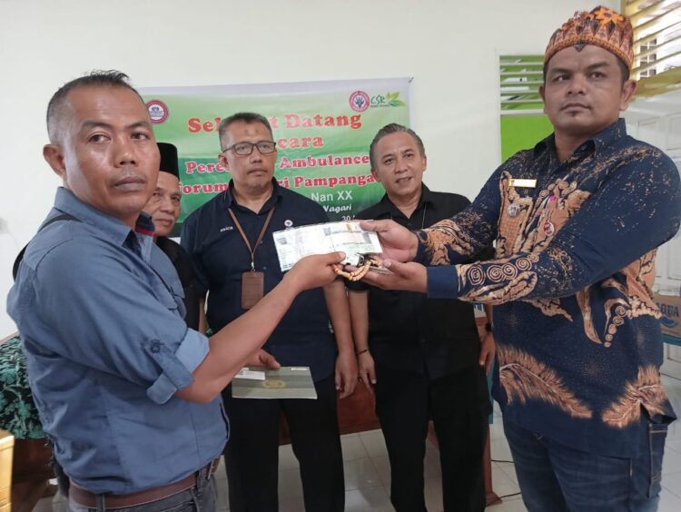 Lurah Pampangan Nan XX, Afrizal Erman (kanan), menyerahkan bantuan ambulance dari PT Semen Padang kepada Ketua Forum Nagari Kelurahan Pampangan Nan XX, Erison, Kamis (30/11/2023). Penyerahan bantuan dari Program Basinergi Mambangun Nagari itu ditandai dengan penyerahan BPKB, STNK dan kunci mobil ambulance. IST