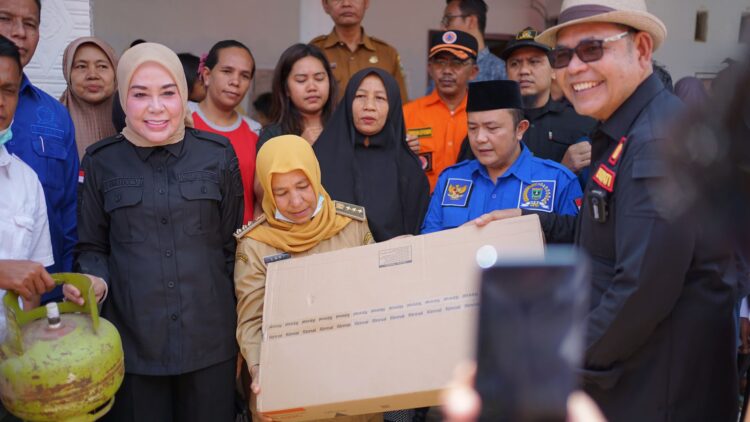 Bupati Solok Epyardi Asda bersama Ketua TP PKK Emiko Epyardi saat menyerahka bantuan kepada masyarakat yang terdampak banjir di Tarusan, Kabupaten Solok pada Senin (18/3/2024).