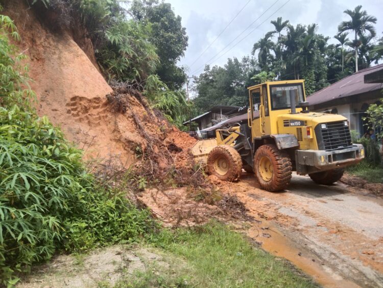 Alat berat milik Dinas PUPR Kabupaten Sijunjung saat membersihkan material longsor dari jalan utama warga yang pagi di jorong Koto Mudiak Nagari Durian Gadang Kecamatan Sijunjung beberapa waktu lalu.