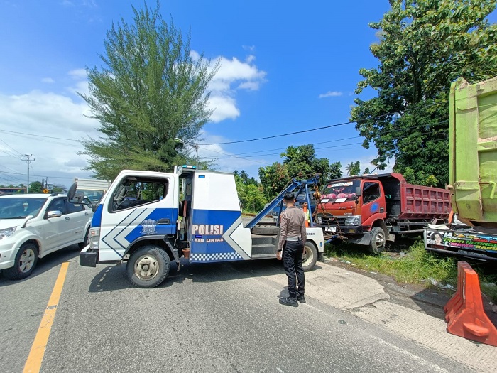 Satlantas Polres Padang Pariaman mengevakuasi truk usai kecelakaan dengan bis tranek. ALDI