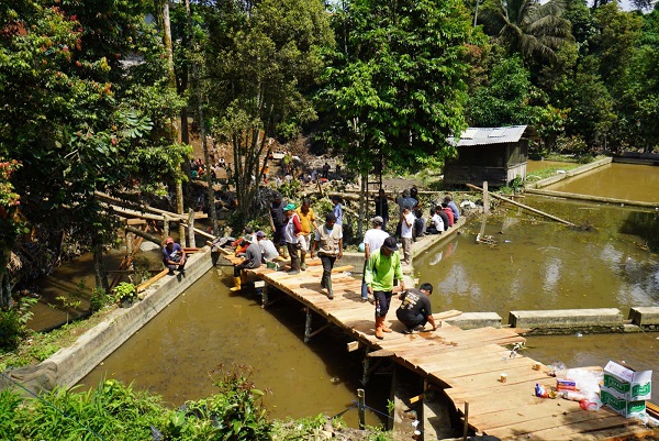 Masyarakat membangun jembatan darurat yang ambruk usai diterjang banjir bandang di Padang Panjang. IST