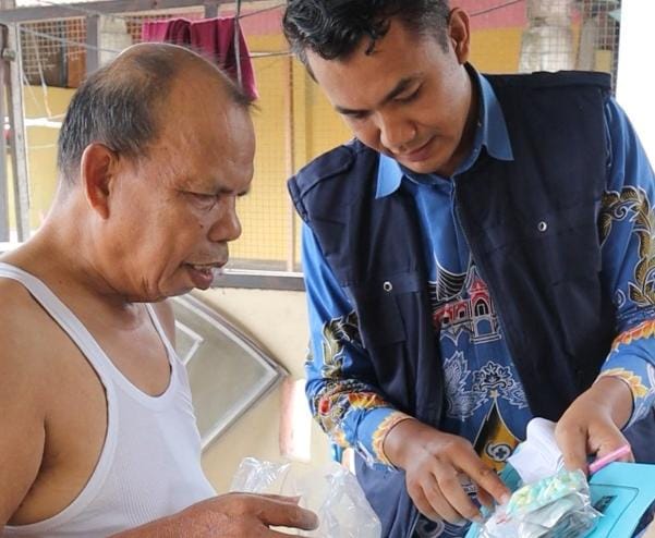 Si Ajo saat mengantarkan obat ke rumah pasien. Mitha.