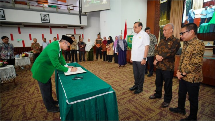 Rektor UNAND Efa Yonnedi menandatangi menandatangani komitmen bersama terkait keterbukaan informasi publik yang disaksikan langsung oleh Ketua Komisi Informasi (KI) Pusat Dr. Ir. Donny Yoesgiantoro dan Komisioner Syawaludin serta KI Provinsi Sumatra Barat, Rabu (10/7) di Convention Hall kampus. IST