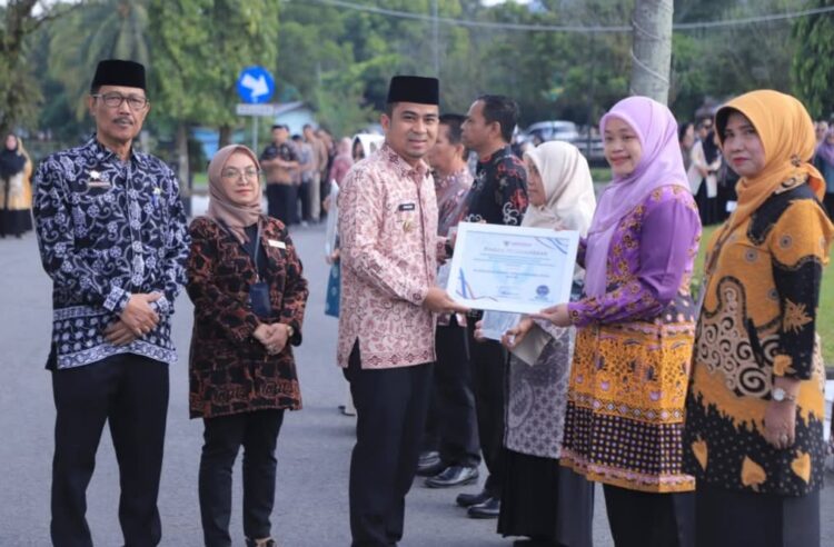 Wakil Wali Kota Solok Dr.H.Ramadhani Kirana Putra menyerahkan penghargaan kepada satuan kerja yang mendapat predikat terbaik atas capaian kinerja tahun 2024, di sela pelaksanaan apel perdana awal tahun 2025 di halaman Kantor Wali Kota Solok, Kamis (2/1). Ist
