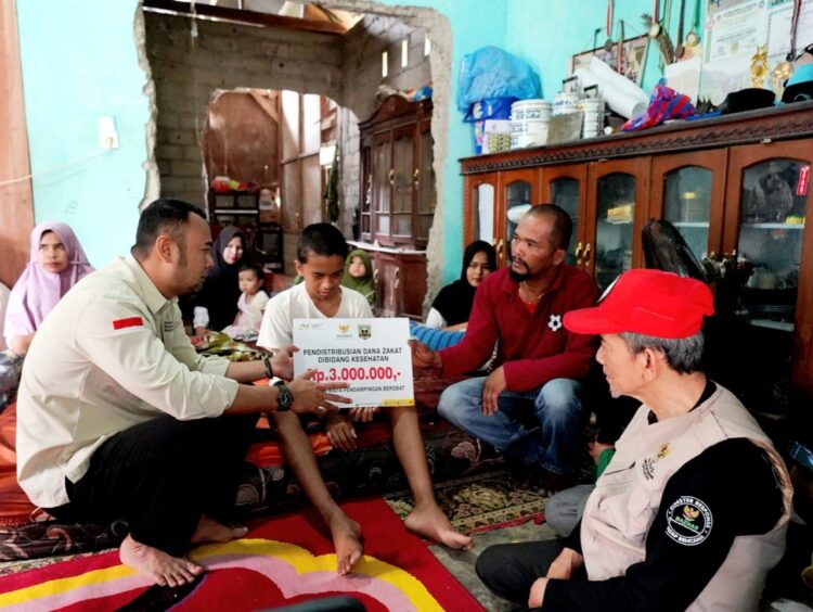 Bupati Sijunjung Benny Dwifa Yuswir, S.STP, M.Si Sutan Gumilang bersama Baznas Sijunjung saat menyerahkan bantuan pengobatan bagi keluarga kurang mampu di Taratak Malintang, Jorong Koto Panjang, Nagari Limo Koto Kecamatan Koto VII, Sabtu (15/3).