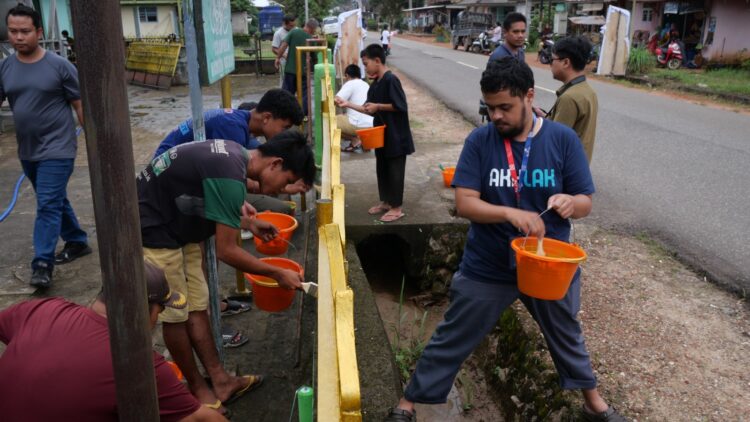 Beberapa Relawan Program "Sobat Aksi BUMN 2025" saat melakukan kegiatan gotong royong mengecat pagar masjid bersama masyarakat setempat pada program "Sobat Aksi BUMN 2025" di Desa Banyuasin, Kecamatan Riau Silip, Kabupaten Bangka, Kepulauan Bangka Belitung yang berlangsung pada Sabtu (15/3). IST
