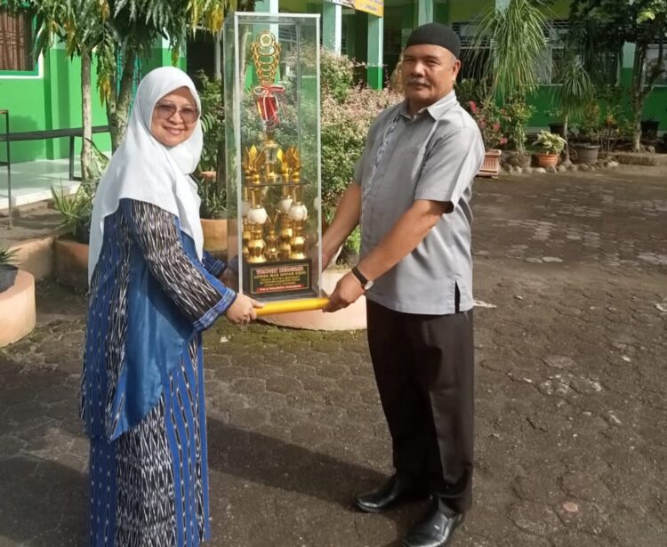 Wismardi saat menyerahkan hadiah kepada siswa pemenang juara umum MAN Kopar Expo. IST