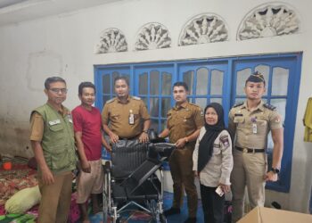 Camat Koto Tangan Fizlan Setiawan menyerahkan kursi roda untuk salah satu warganya Yasni. IST