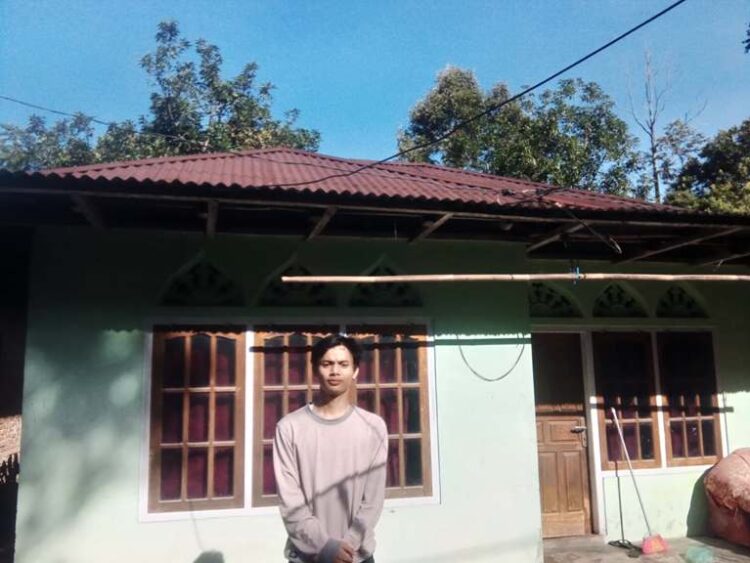 Devit Febriansyah di depan rumah sederhananya di di Jorong Bukit Malanca, Nagari Malalak Timur, Kecamatan Malalak, Kabupaten Agam. IST