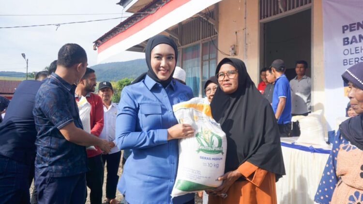 SERAHKAN BANTUAN—Anggota Komisi IV DPR RI, Cindy Monica Salsabila Setiawan menyerahkan bantuan pangan kepada salah seorang warga di Talamau Kabupaten Pasaman Barat. OSNIWATI