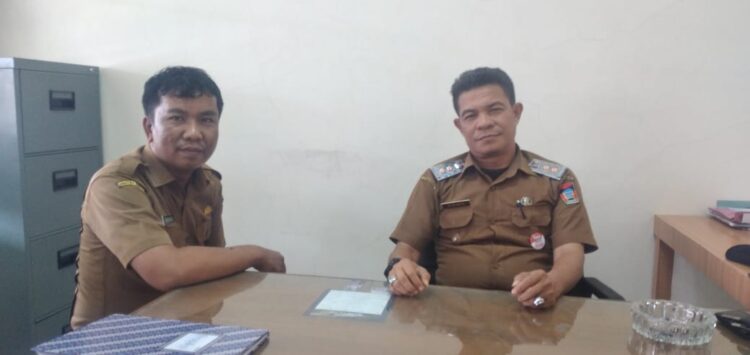 Lurah Alai Parak Kopi Afrimen S.Sos., bersama Kasi Pemerintahan Noviandi, di ruang kerjanya, Senin (4/8).  ATVIARNI