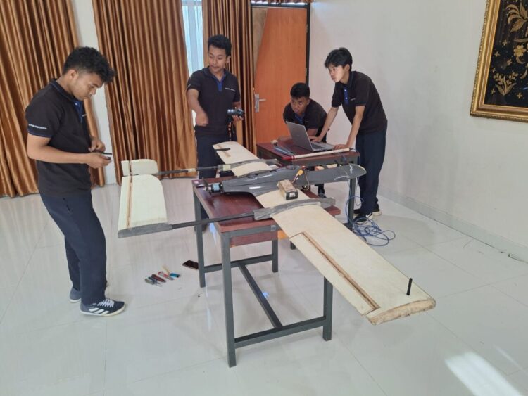 Ketua Dewa Manggala Team, Pradipta Septrian Jati (di tengah) selaku peserta KRTI sedang mempersiapkan pesawat yang akan dilombakan, Rabu (15/10) kemarin. IST