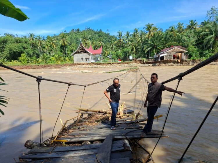 Anggota DPRD Kabupaten Pesisir Selatan, Novermal saat meninjau jembatan gantung Pelangai Gadang yang tak kunjung diperbaiki. IST