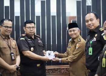 Wakil Wali Kota Solok Suryadi Nurdal didampingi Sekda Desmon, menerima cendera mata dari Kajari Solok Medie, berupa program edukatif dalam rangka peringatan HAKORDIA 2025, di ruang kerja Wawako Solok, Selasa (9/12). IST
