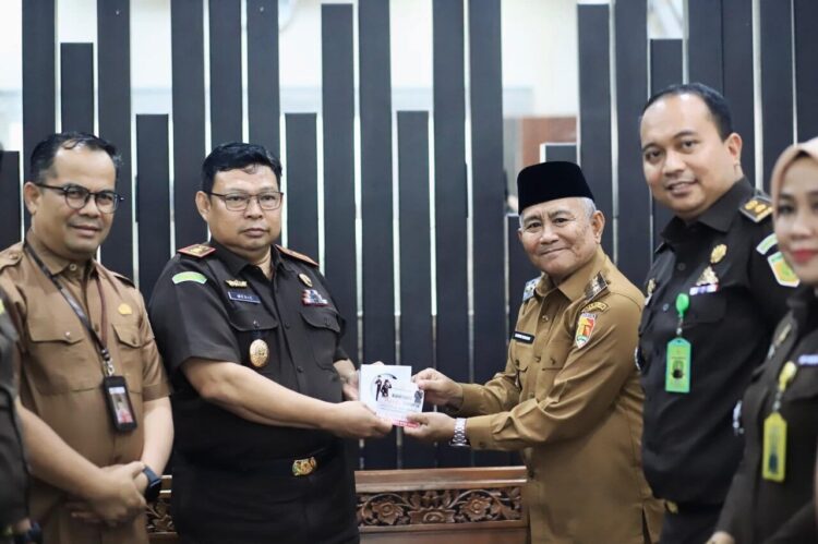 Wakil Wali Kota Solok Suryadi Nurdal didampingi Sekda Desmon, menerima cendera mata dari Kajari Solok Medie, berupa program edukatif dalam rangka peringatan HAKORDIA 2025, di ruang kerja Wawako Solok, Selasa (9/12). IST