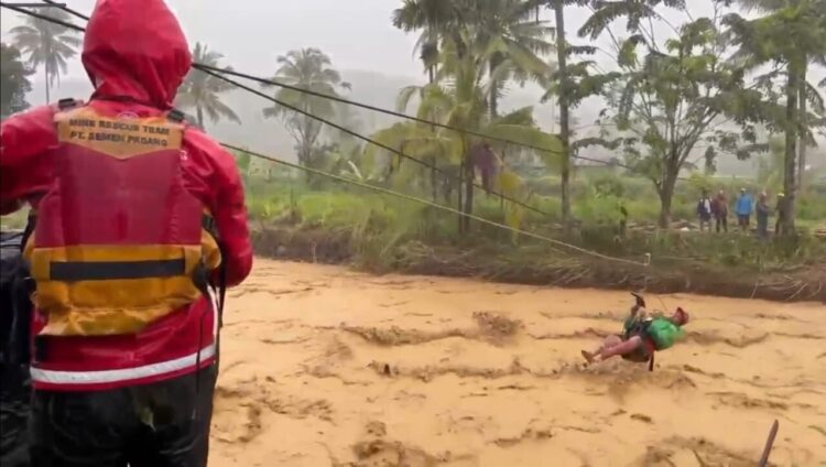 Personel Tim Reaksi Cepat (TRC) PT Semen Padang bersama tim gabungan lainnya, terjun langsung menembus derasnya arus Sungai Batang Kuranji di Koto Tuo, Kecamatan Pauh, untuk menyelamatkan tiga warga yang terjebak di tengah pulau sungai pada Kamis (27/11). IST