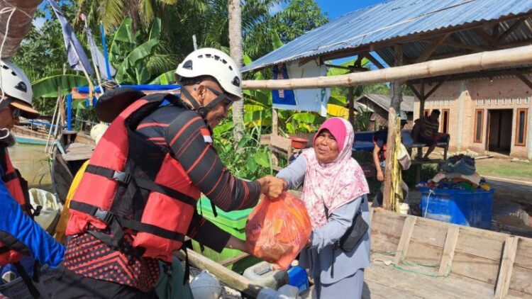 Relawan menyerahkan dukungan sembako kepada warga terdampak bencana di Desa Alur Kapal dan Kelurahan Pematang Cengal, Tanjung Pura, Langkat, Sumatra Utara, Jumat (5/12).